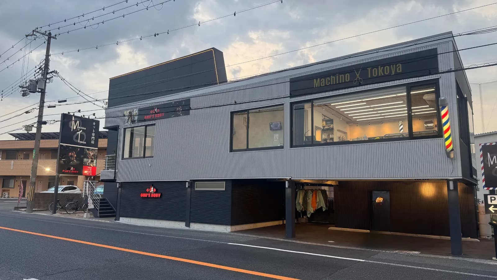 「Machino Tokoya」の看板とバーバーポールが目印の店舗外観