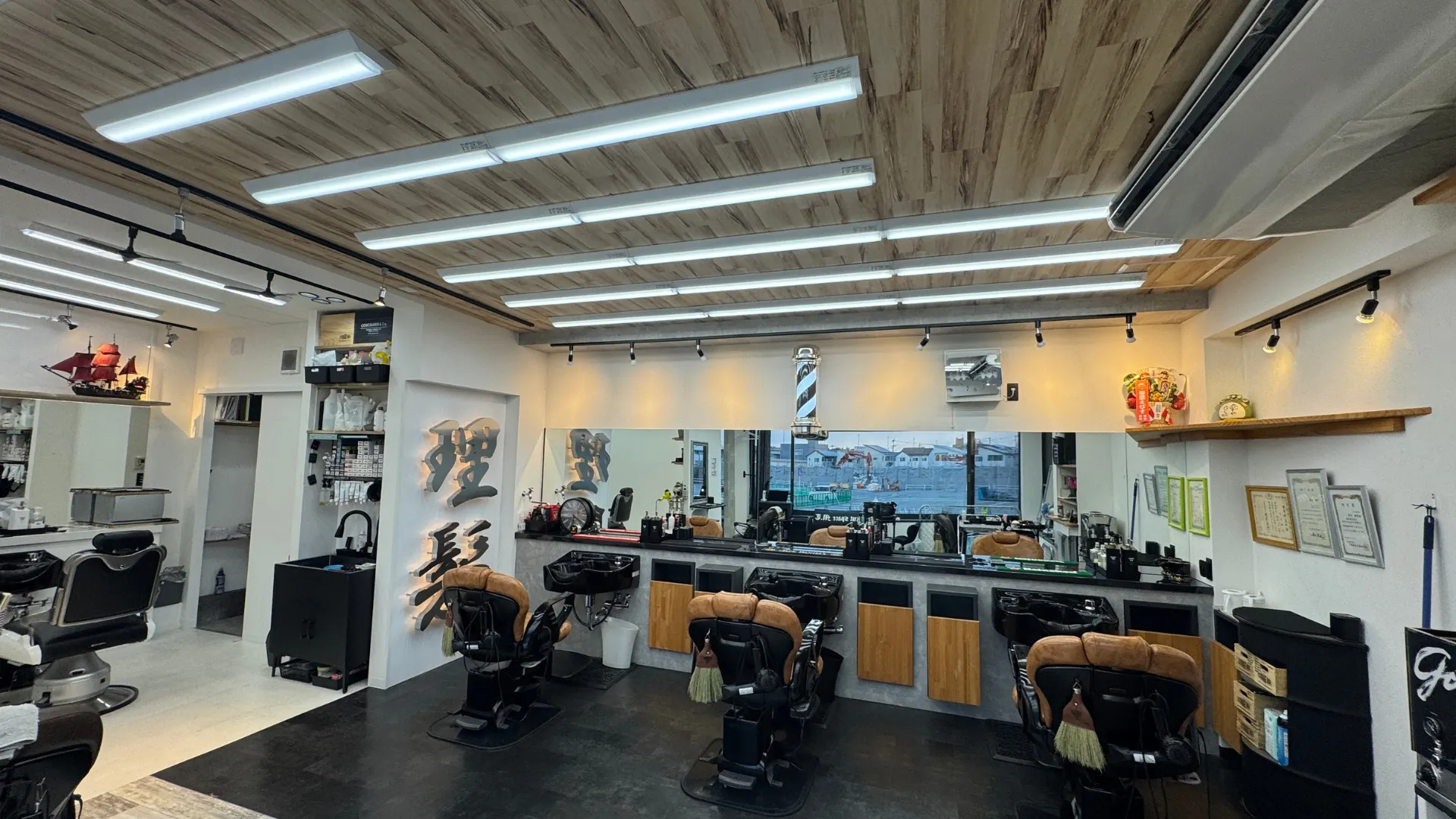 まちのとこやの店内。「理髪」の看板とバーバーチェアが並ぶ